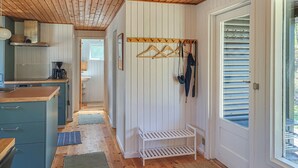 A kitchen with wooden cabinets, a coffee machine, and a hanging coat rack. - Gorgeous home in Læsø with WiFi (Læsø)