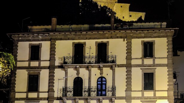 Um edifício histórico com várias sacadas e uma entrada imponente.