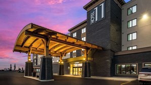 Un hotel con entrada techada, varios pisos y un vestíbulo destacado.