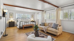 A well-lit living room with a bed, a sofa, and a coffee table.