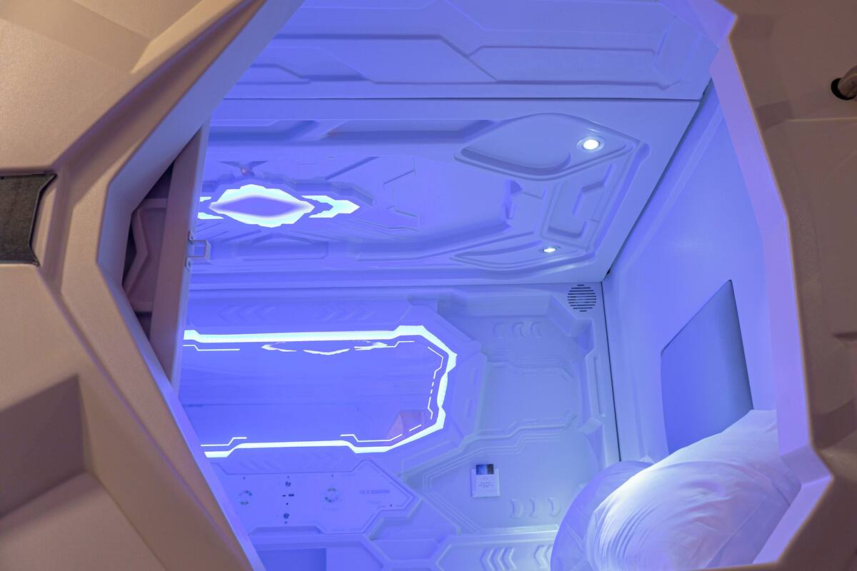 A futuristic interior with geometric patterns and illuminated blue lines on the walls.