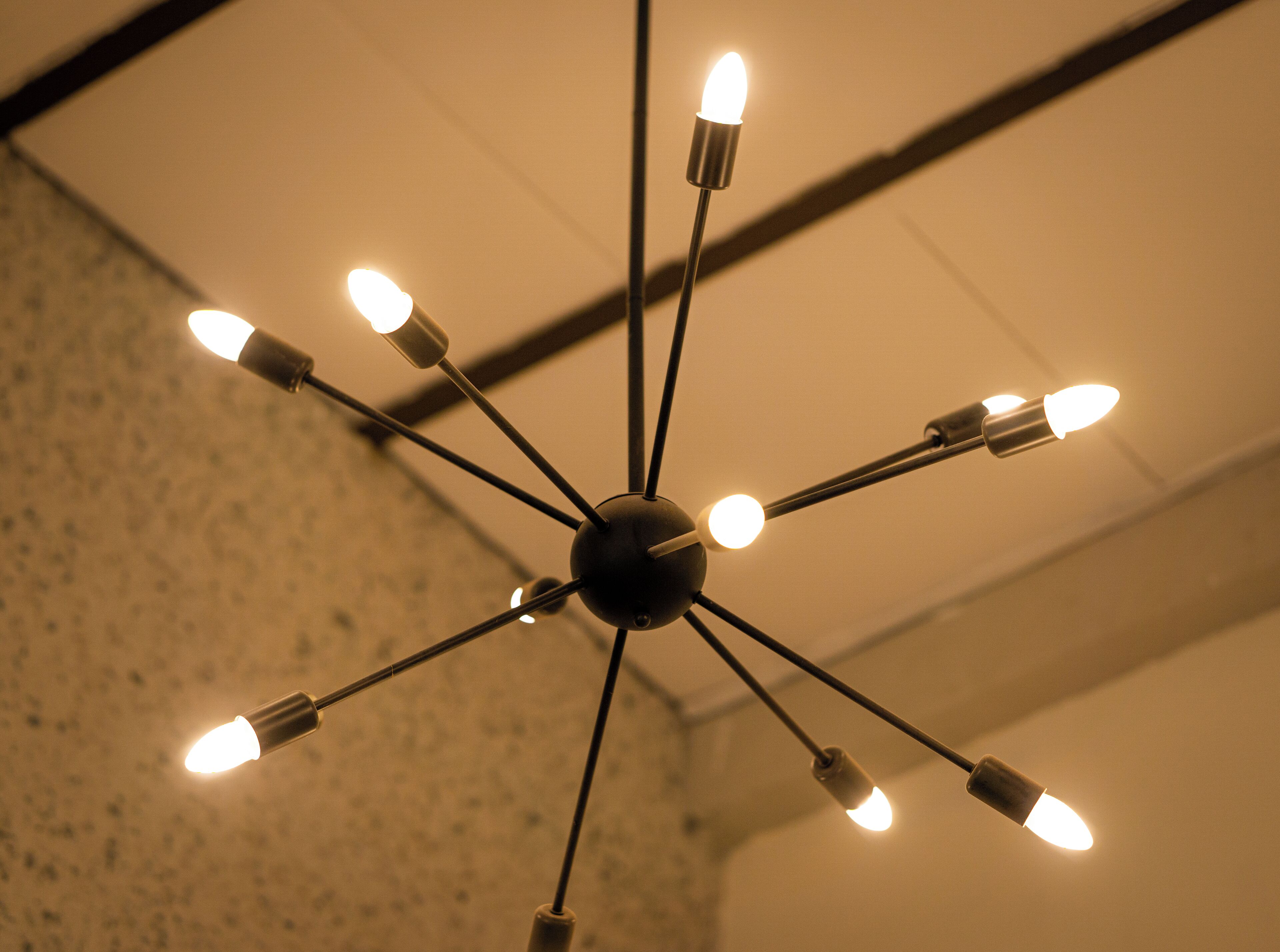 A ceiling light fixture with multiple bulbs arranged in a radial pattern.