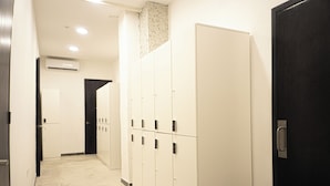 A hallway with lockers, a door, and an air conditioning unit.