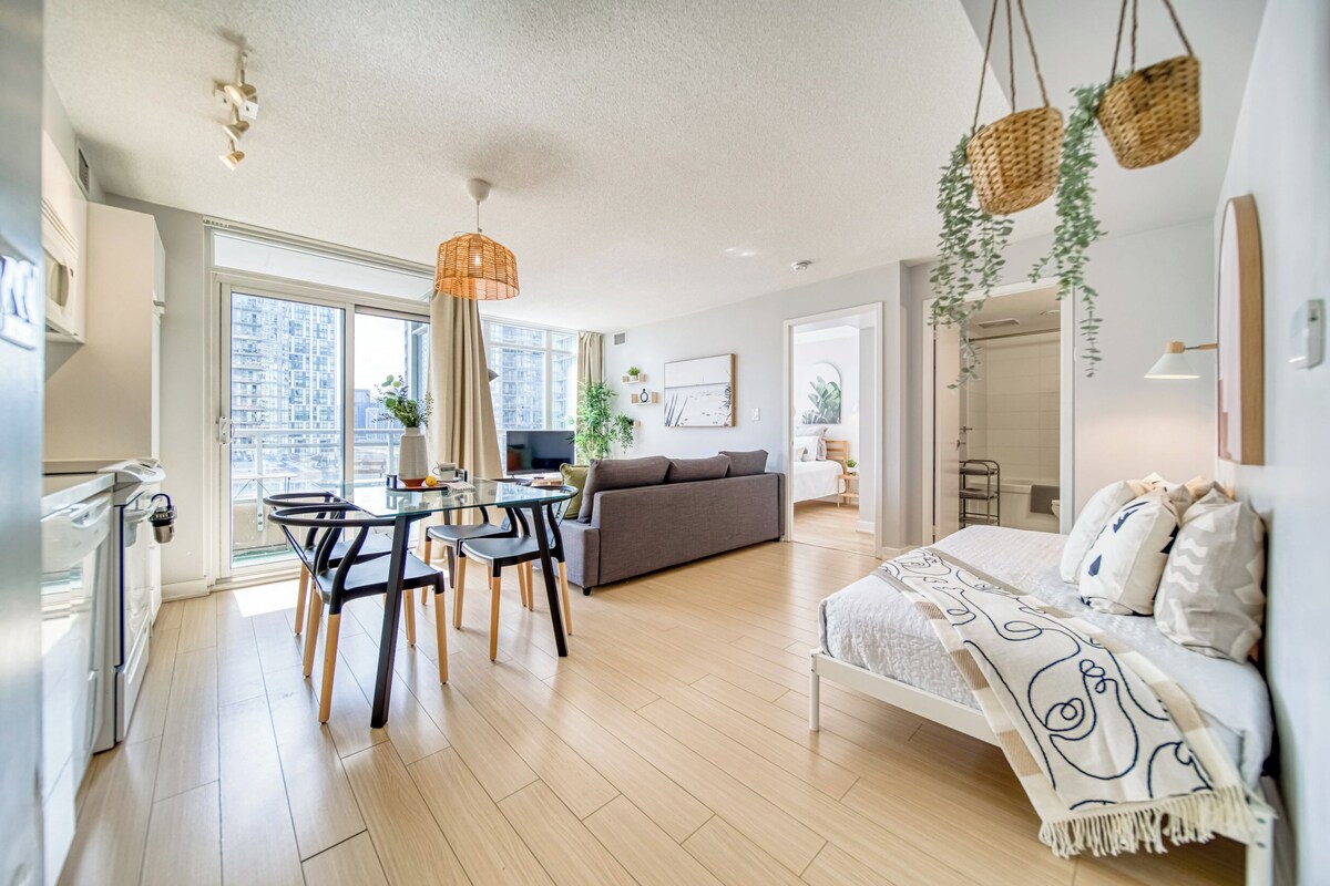 Um apartamento moderno com área de refeições, sofá e cama.