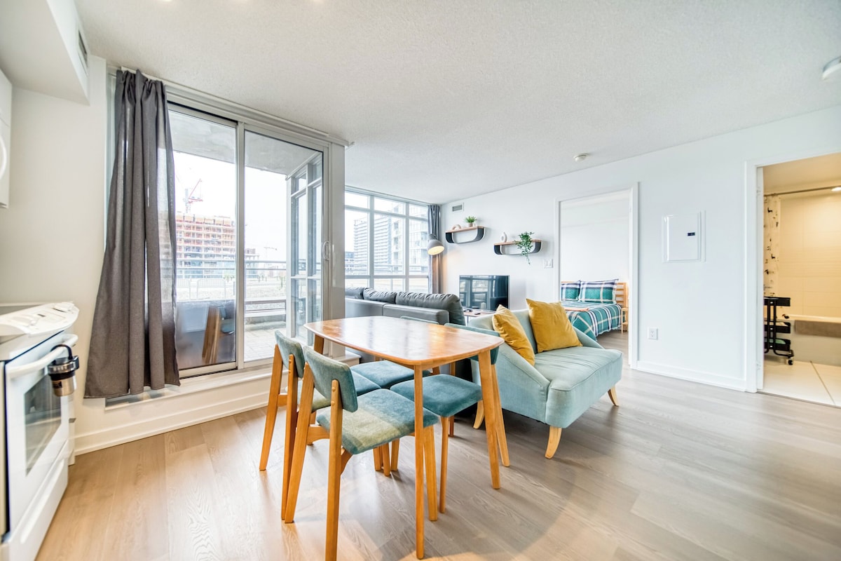 Apartamento moderno com área de jantar, sofá e vista para a cidade.