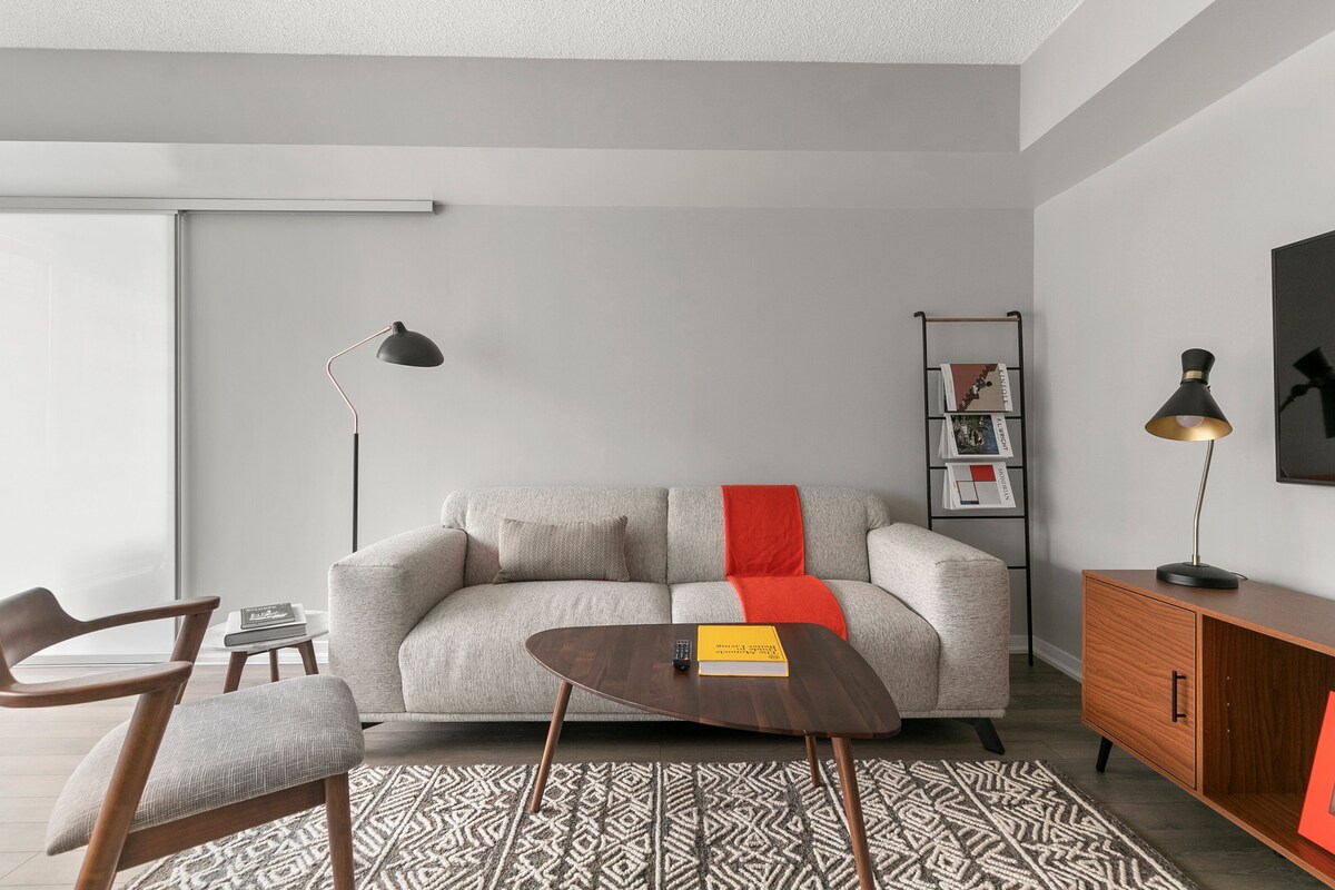 Uma sala de estar moderna com um sofá, mesa de centro e estante.
