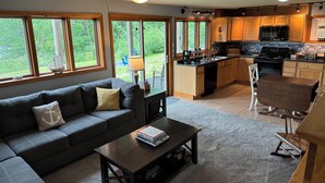 A modern kitchen with wooden cabinets, a black stove, and a microwave.