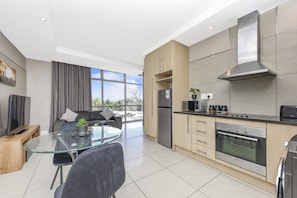 A modern kitchen with a built-in oven, microwave, and a stainless steel range hood.
