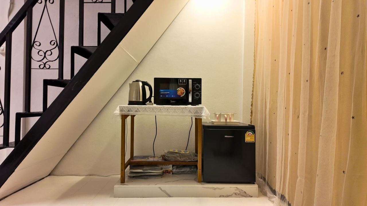 A compact kitchenette with a microwave, coffee maker, and refrigerator.