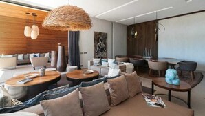 Un salon moderne avec un canapé, une table basse et un luminaire suspendu.