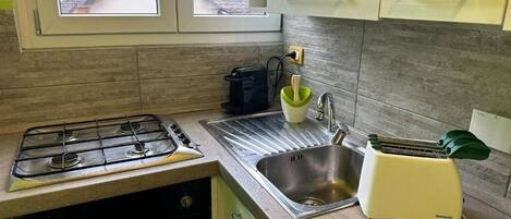 Een koelkast, een oven, een kookplaat, een koffiezetapparaat/waterkoker