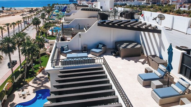 A rooftop terrace with outdoor seating, a pool, and a view of the beach and ocean. - CABO PENTHOUSE CONDO - Rooftop deck with Private Jacuzzi at Puerta Cabos Village (Cabo San Lucas)