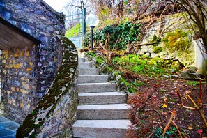 A stone staircase leading up to a building with a metal gate and a street lamp.