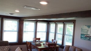 A spacious living area with a wooden dining table surrounded by chairs, a leather sofa, and a leather armchair. Large windows with blinds allow natural light to enter. - Pointe Haven,  
right off the North Channel
WITH OR WITHOUT PONTOON!
480/330 (Algonac)