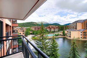 A view from a balcony overlooking a lake with buildings in the background. - Village at Breck with Once-in-a-lifetime views! Ski-in and out and steps to town (Breckenridge)