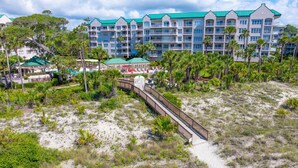 A resort with a beachside walkway leading to a building with multiple balconies and a green roof. - 4205 Windsor @ Palmetto Dunes | Oceanfront Villa | Pool & Spa | Moments to Beach (Hilton Head Island)