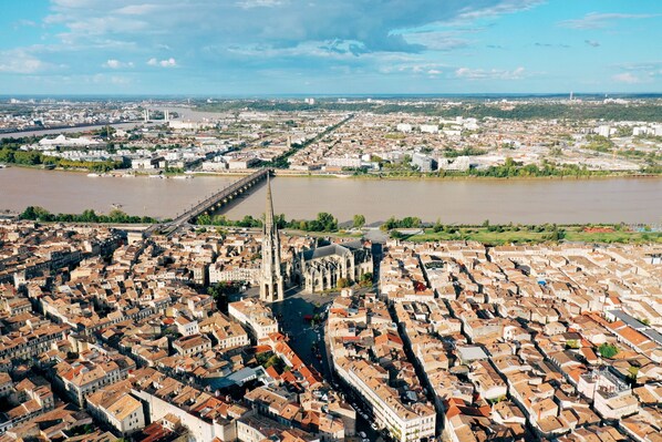 Vista aérea de una ciudad con una catedral destacada, un río y un puente.