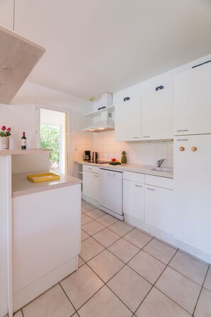 Una cocina moderna con armarios blancos, una bandeja amarilla y una cafetera.