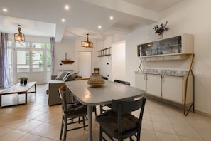 A modern kitchen with a marble countertop, a dining table, and a built-in cabinet.