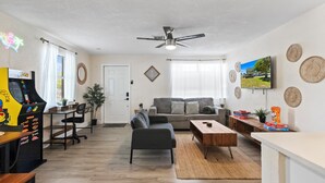 A modern living room with a sofa, coffee table, and gaming console. - Walkable Gem : Retro Arcades : Near Lauderdale-by-the-Sea (Fort Lauderdale)