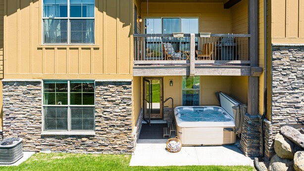 A two-story house with a stone facade, a balcony with outdoor furniture, and a hot tub. - Close to World-class Ski Resorts  and Summer Activities on the Lake (Heber City)