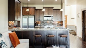 A modern kitchen with dark wood cabinets, stainless steel appliances, and a granite countertop. - Close to World-class Ski Resorts  and Summer Activities on the Lake (Heber City)