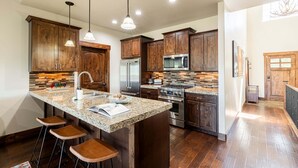 A modern kitchen with granite countertops, stainless steel appliances, and wooden cabinets. - Close to World-class Ski Resorts  and Summer Activities on the Lake (Heber City)