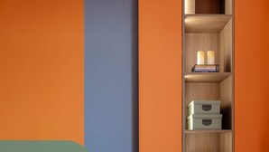 A modern living room with a sofa, a built-in wooden shelf with storage boxes, and a wall with a geometric design. - Playful & Bright 1BR near The Faculty of Law (Bucharest)