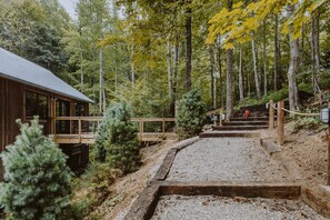 Une cabane en bois avec un chemin de gravier menant à un escalier en bois.