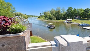 A river with boats, a dock, and a house in the background.