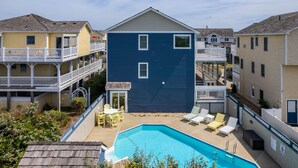 A residential building with a swimming pool, outdoor seating, and a balcony. - Waves of Joy: Oceanside, Private Heated Pool, Hot Tub (Nags Head)