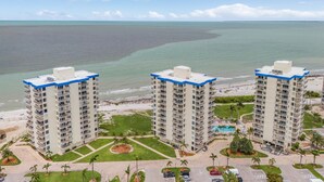 Un hotel de gran altura con varios pisos, un patio central y vista a la playa.