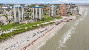 Un complejo hotelero frente al mar con varias torres, una playa y un puerto deportivo.