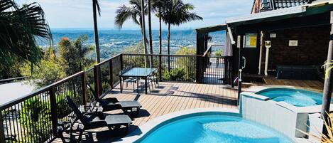 Una piscina al aire libre, sombrillas, sillones reclinables de piscina