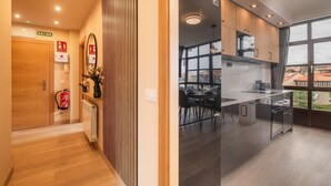 A modern kitchen with a large window, a dining area, and a hallway with a fire extinguisher and exit signs.