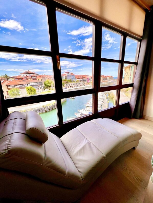 Una habitación con un ventanal que ofrece vista a un puerto y edificios.