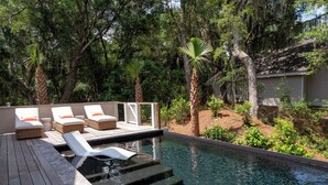 A pool area with lounge chairs and a wooden deck. - Fabulous 5 BR/5.5 BA Home! New Construction! Pool! Screen Porch! Amenity access included (Seabrook Island)
