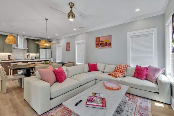 Unit 1 - 2nd Floor: Warm and inviting open-concept living space seamlessly flowing the designer furnished living room with the fully equipped kitchen and dining area.