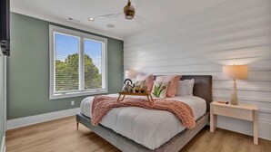 A bedroom with a bed, bedside table, lamp, window, and ceiling fan. - Resonant - 2 Townhomes - 2 Private Rooftop Decks (Nashville)
