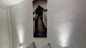 A bedroom with a bed, two bedside lamps, a nightstand, and a wall-mounted picture. - Apartamento Santiago de la Ribera (San Javier)