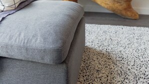 A modern living room with a grey sofa, a wooden coffee table, a mounted flat-screen TV, and a potted plant. - Trendy & Cozy Downtown Halifax Condo (Halifax)