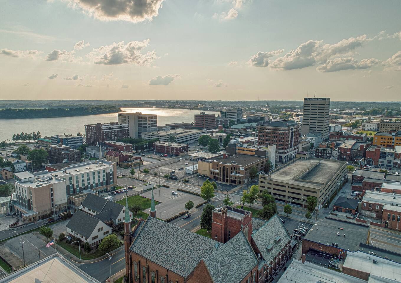 A cityscape with a mix of modern and historic buildings, a river in the background, and a clear sky.