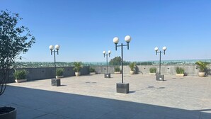A rooftop terrace with potted plants and street lamps. - Jbr park hotel (Goiania)
