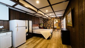 A compact bedroom with a bed, bedside table, and a small kitchenette with a refrigerator. - Charming castle with 7 bedrooms and WiFi, AC in Coe Hill (Coe Hill)