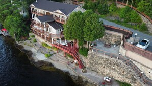 A multi-story waterfront property with balconies, a stone retaining wall, and a dock. - Charming castle with 7 bedrooms and WiFi, AC in Coe Hill (Coe Hill)