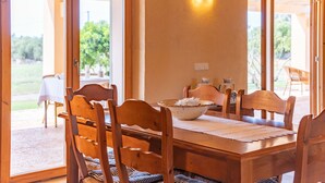 Una mesa de comedor de madera con sillas, un tazón y una lámpara en la pared.