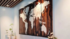 A modern bar area with a wooden bar counter, stools, and a large abstract painting on the wall. - The Paragon Boracay Suites (Boracay Island)