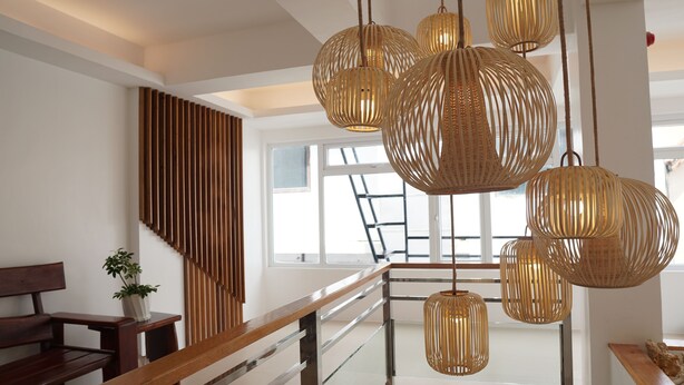 A modern interior with a wooden staircase, a bench, and hanging wicker pendant lights. - The Paragon Boracay Suites (Boracay Island)