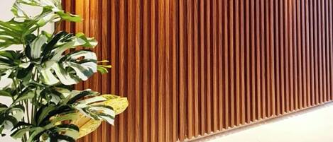 A modern interior with a vertical wooden panel wall and recessed lighting.