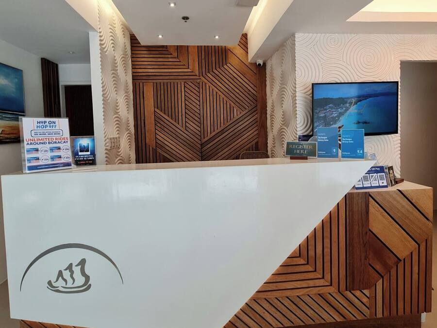 A reception desk with a modern design, featuring a logo, a signboard for unlimited rides, and a registration area.